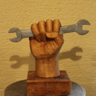 Holzschnitzerei: Skulptur „Hand mit Schraubenschlüssel“